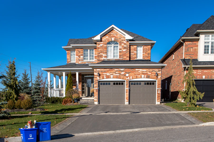Two-car garage with sectional doors under a bright sky