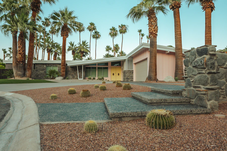 Mid-century desert home with stone accents, palms, and a white garage door